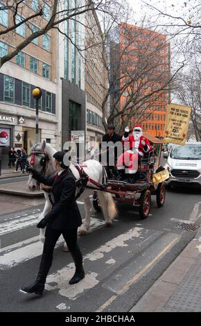 Londra, Regno Unito. 18th dicembre 2021. Una carrozza trainata da cavalli con un Babbo Natale passa attraverso il centro di Londra per raccogliere fondi per un'organizzazione di beneficenza per rifugiati, Care4Calais. Foto: Richard Grey/Alamy Live News Foto Stock