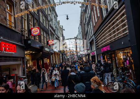 Amsterdam, Paesi Bassi. 18th Dic 2021. Nel centro di Amsterdam si vedono più persone del solito fare shopping. Le strade dello shopping sono più trafficate che mai a causa di persone che anticipano la chiusura di negozi non essenziali per fermare la rapida evoluzione della variante più contagiosa di Omicron. (Foto di Ana Fernandez/SOPA Images/Sipa USA) Credit: Sipa USA/Alamy Live News Foto Stock
