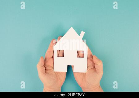 Tenendo una piccola casa di carta nelle mani, planando una nuova casa, bene immobile, proprietà Foto Stock