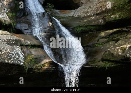Acqua che cade dalle rocce con un piccolo ruscello Foto Stock