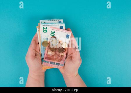 Tenere in mano banconote e monete in euro, contare denaro, risparmiare reddito, copiare spazio per il testo Foto Stock