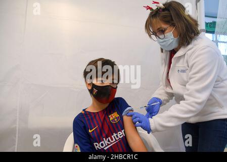 Calafell, Tarragona, Spagna. 30th Set 2021. Un infermiere somministra una dose di vaccino Pfizer-BioNTech a un bambino in un centro di vaccinazione. Il Dipartimento di Salute della Catalogna attraverso la Xarxa Santa Tecla de Tarragona nella prevenzione del contagio di SARS-cov-2 Covid-19 e il nuovo ceppo contagioso Ã³micron ha somministrato la prima dose di COMIRNATY Vaccino (COVID-19 mRNA vaccino, Pfizer-BioNTech) a ragazzi e ragazze di età compresa tra i 5 e i 11 anni presso il centro di vaccinazione situato nel Joan Ortoll Sports Pavilion di Calafell. (Credit Image: © Ramon Costa/SOPA Images via ZUMA Press W Foto Stock