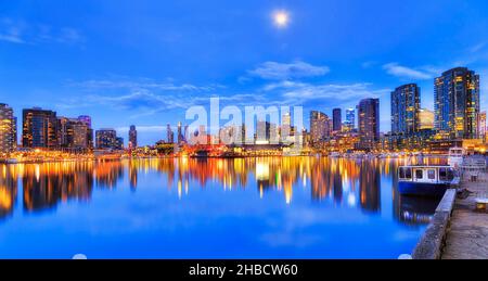 Ampio e tranquillo riflesso di Docklands moderno paesaggio urbano nella città di Melbourne al susnet con luci luminose. Foto Stock