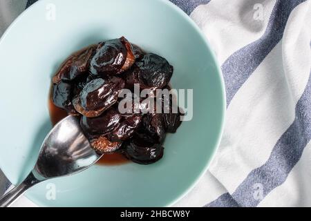 prugne semplici e stufate cotte in una ciotola frutta secca di prugne sul tavolo Foto Stock