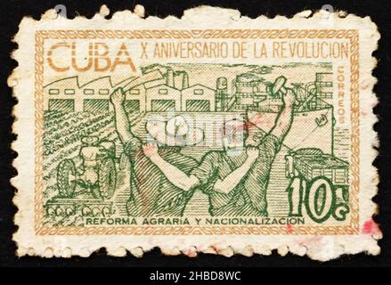 CUBA - CIRCA 1963: Un francobollo stampato a Cuba mostra la riforma agricola e la nazionalizzazione dell'industria, 10th anniversario della rivoluzione cubana, circa Foto Stock