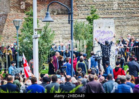 Tbilisi, Georgia - 9 aprile 2021: Giorgi Gachechiladze scrive 'Dio è amore' sul segmento delle mura di Berlino in piazza d'Europa. Foto Stock