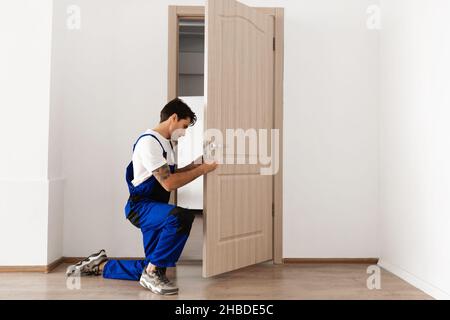 Installazione di una serratura sulla porta di ingresso Foto Stock