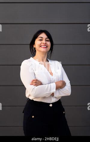 felice donna d'affari sorridente con le braccia incrociate, concetto di imprenditore di successo e stile di vita urbano, spazio di copia per il testo Foto Stock