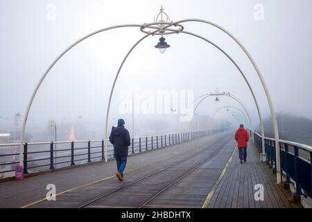 Southport, Merseyside. Meteo Regno Unito; 18th Dicembre, 2021. Densa nebbia dopo la notte più fredda dell'anno nella città costiera nord-occidentale. I residenti del resort si allenano al mattino sul lungomare in condizioni di nebbia fredda. Credit; MediaWordImages/AlamyLiveNews Foto Stock