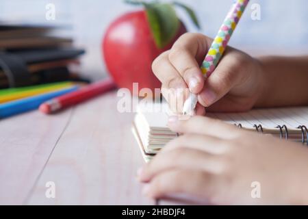 scrittura della mano del bambino sul blocco note Foto Stock