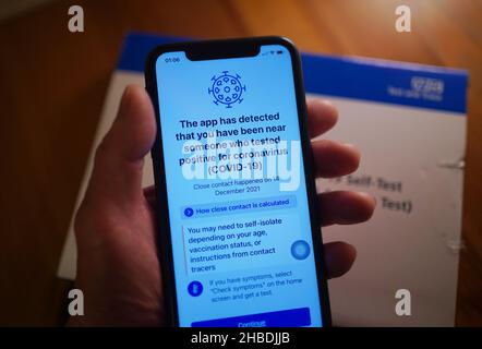 Un avviso è emesso dall'app di tracciamento dei contatti per coronavirus NHS - a causa di una persona che è stata in stretto contatto con qualcuno che ha coronavirus - visualizzata su un telefono cellulare a Londra, Dove sono state introdotte nuove restrizioni per rallentare la diffusione della variante Omicron del coronavirus. Data foto: Domenica 19 dicembre 2021. Foto Stock