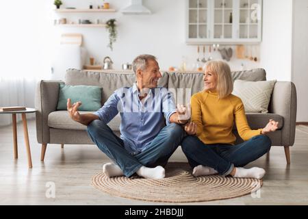 Coppia matura che fa Yoga insieme seduto in Lotus posizione Indoor Foto Stock