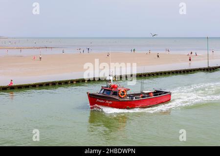 Piccola barca rossa da pesca Jenifer's Pride entra nel fiume Arun da East Beach, Littlehampton, una località turistica della costa meridionale nel Sussex occidentale in estate Foto Stock