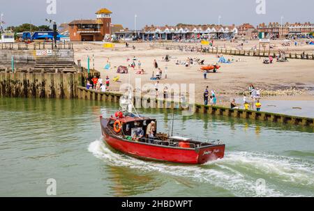 Piccola barca rossa da pesca Jenifer's Pride entra nel fiume Arun da East Beach, Littlehampton, una località turistica della costa meridionale nel Sussex occidentale in estate Foto Stock