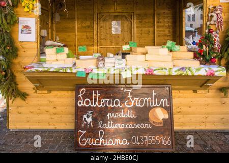 Belluno, Italia - Dicembre 11th 2021. Una bancarella di formaggi in un tradizionale mercatino di Natale in Piazza dei Martiri nel centro storico Foto Stock