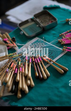 Lavori di lacemaker in corso, primo piano. Tavola, bobine e filo. Foto Stock