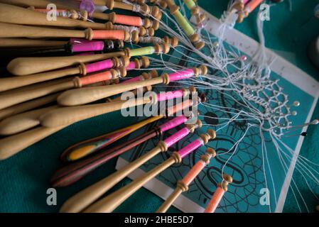 Lavori di lacemaker in corso, primo piano. Tavola, bobine e filo. Foto Stock