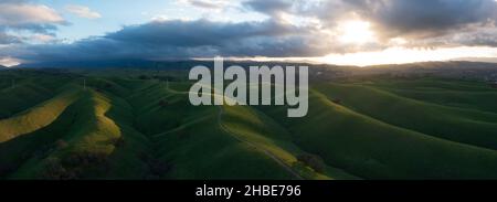 Le nubi basse si muovono su creste soleggiate e ricoperte di erba nella splendida regione di Tri-Valley nella California settentrionale, ad est della Baia di San Francisco. Foto Stock