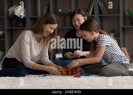 Famiglia amichevole di 3 donne di età diverse che giocano insieme costruttore Foto Stock