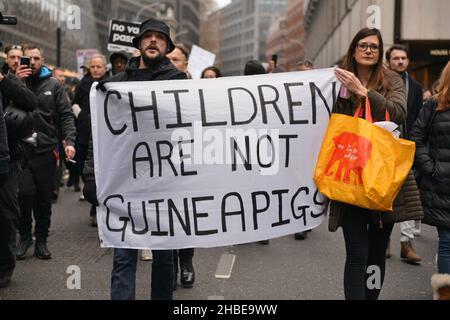 I manifestanti si marciare con una bandiera che esprime la loro opinione, durante la dimostrazione. I manifestanti anti anti anti anti-vaccino e anti-vaccino passano Uniti dagli oppositori delle restrizioni di Covid 19, si sono riuniti a Parliament Square e hanno marciato attraverso il centro di Londra. Foto Stock