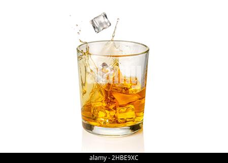 Bicchiere di whiskey, whiskey o bourbon con cubetti di ghiaccio cadenti con spruzzi, isolato su bianco Foto Stock