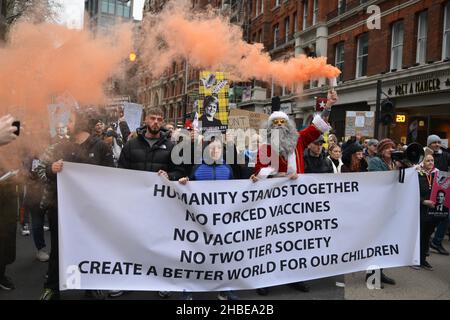 I manifestanti si marciare con una bandiera che esprime la loro opinione, durante la dimostrazione. I manifestanti anti anti anti anti-vaccino e anti-vaccino passano Uniti dagli oppositori delle restrizioni di Covid 19, si sono riuniti a Parliament Square e hanno marciato attraverso il centro di Londra. Foto Stock