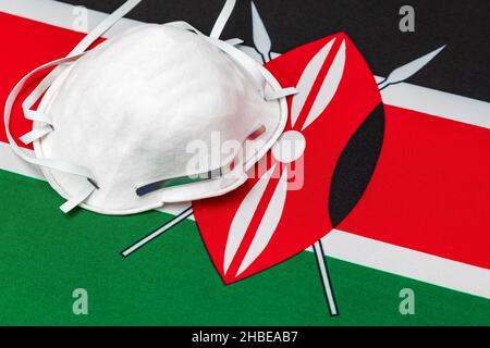 Bandiera Kenya e maschera facciale N95. Concetto di Covid-19 coronavirus blocco, divieto di viaggio e crisi sanitaria Foto Stock