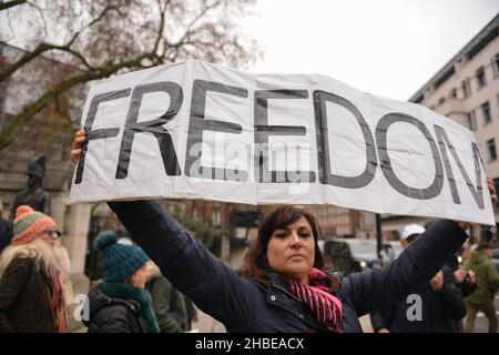 Un manifestante tiene una bandiera che dice 'Freedom', durante la dimostrazione. I manifestanti anti anti anti anti-vaccino e anti-vaccino passano Uniti dagli oppositori delle restrizioni di Covid 19, si sono riuniti a Parliament Square e hanno marciato attraverso il centro di Londra. Foto Stock