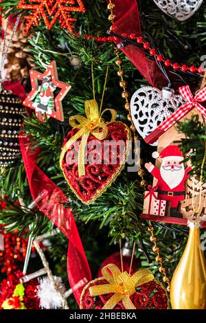 Splendidi ornamenti e decorazioni natalizie appesi sull'albero di Natale Foto Stock