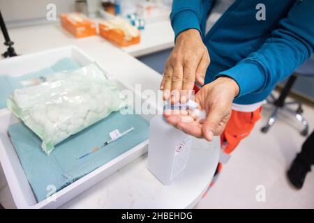 Un operatore medico disinfetta le mani prima di dare il benvenuto al Ministro della Sanità sloveno Janez Poklukar quando arriva al Bled Health Center per ottenere il suo vaccino COVID-19 e iniziare ufficialmente una campagna di promozione vaccinale di cinque giorni a livello nazionale. Il Ministro della Sanità sloveno Janez Poklukar ha aperto una campagna di promozione della vaccinazione COVID-19 di cinque giorni, in cui 62 centri di vaccinazione in tutto il paese e le unità di vaccinazione mobile lavorano straordinari, il personale della protezione civile e della Croce Rossa forniscono il trasporto gratuito verso i siti di vaccinazione, e centri di vaccinazione notturna sono stabiliti. (Foto Foto Stock