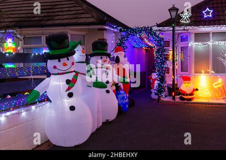 Parkstone, Poole, Dorset, Regno Unito. 19th dicembre 2021. L'ultimo fine settimana prima di Natale e i visitatori da vicino e da lontano si dirigono verso la famosa mostra di luci di Natale sulle proprietà di Runton Road, dove i proprietari competono per la migliore esposizione e per raccogliere soldi per varie associazioni di beneficenza. Credit: Carolyn Jenkins/Alamy Live News Foto Stock