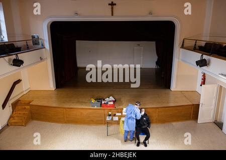 Naklo, Slovenia. 19th Dic 2021. Un uomo è testato per la COVID-19 in un centro culturale, uno dei 62 centri di vaccinazione che lavorano straordinari durante una campagna di vaccinazione a livello nazionale. In Slovenia inizia una campagna di promozione della vaccinazione COVID-19 di cinque giorni, in cui 62 centri di vaccinazione nel paese e le unità di vaccinazione mobile lavorano straordinari, il personale della protezione civile e della Croce Rossa fornisce il trasporto gratuito ai siti di vaccinazione e vengono istituiti centri di vaccinazione notturna. Credit: SOPA Images Limited/Alamy Live News Foto Stock