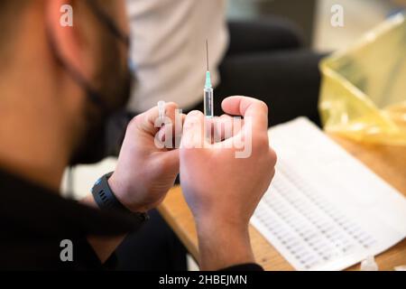 Naklo, Slovenia. 19th Dic 2021. Un operatore medico si prepara a somministrare un vaccino COVID-19 in un'unità di vaccinazione mobile durante una campagna di promozione della vaccinazione a livello nazionale. In Slovenia inizia una campagna di promozione della vaccinazione COVID-19 di cinque giorni, in cui 62 centri di vaccinazione nel paese e le unità di vaccinazione mobile lavorano straordinari, il personale della protezione civile e della Croce Rossa fornisce il trasporto gratuito ai siti di vaccinazione e vengono istituiti centri di vaccinazione notturna. Credit: SOPA Images Limited/Alamy Live News Foto Stock