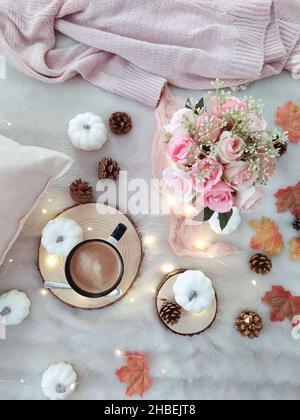 Vista dall'alto di una tazza di caffè con fiori, luci fairy e decorazioni autunnali Foto Stock