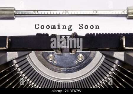 Le parole 'Cooming soon' digitate sulla macchina da scrivere retrò. Foto Stock