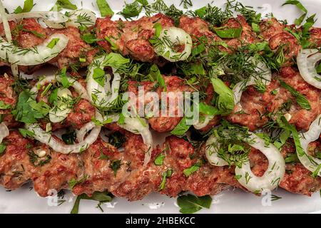 LULYA-KEBAB con erbe e cipolle su un piatto Foto Stock