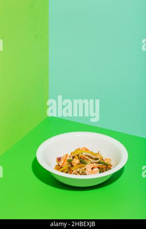 Spiced Stir Fried spagcioso Noodle istantaneo con pesce e basilico su verde Foto Stock