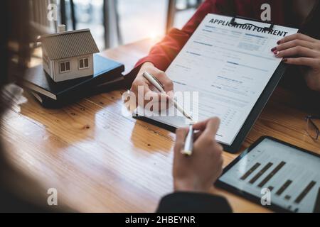 Primo piano di Business donna o agente che punta e firma accordo per la casa d'acquisto. Concetto di Bank manager. Foto Stock