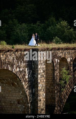 Vorokhta, Ucraina 28 luglio 2021: Un ragazzo e una ragazza camminano sul vecchio ponte, un viadotto in Ucraina. Foto Stock