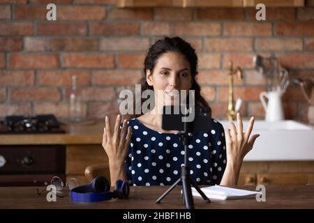 Concentrata giovane ispanica donna che parla video educativo di registrazione. Foto Stock