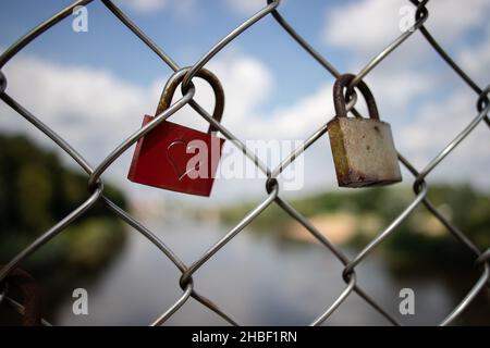dettaglio di serrature arrugginite con un simbolo di cuore su una recinzione che simboleggia l'amore infinito e romanticismo Foto Stock