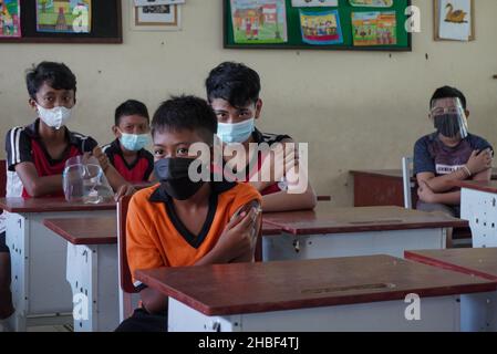 Denpasar, Indonesia. 15th Dic 2021. Gli studenti sono visti in attesa nella sala di osservazione dopo la vaccinazione. La Scuola elementare 33 di Dangin Puri, Denpasar, Bali, ha iniziato la vaccinazione di Covid-19 per gli studenti di 6-11 anni, in quanto l'Indonesia continua ad aumentare il numero delle vaccinazioni dei cittadini al fine di prevenire l'ulteriore diffusione del coronavirus Covid-19. (Foto di Dicky Bisinglasi/SOPA Images/Sipa USA) Credit: Sipa USA/Alamy Live News Foto Stock