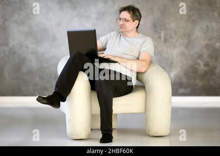 Uomo maturo che lavora da casa utilizzando un laptop. Foto Stock