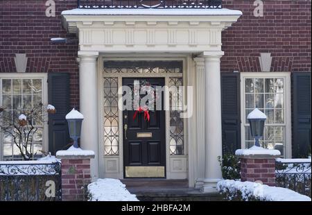 Tradizionale casa in mattoni con ingresso portico e decorazione natalizia sulla porta d'ingresso Foto Stock