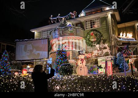 Halifax, Nuova Scozia, Canada. Dicembre 19th, 2021. Due fratelli Halifax South End stanno continuando la loro tradizione di grandi esposizioni di luce di Natale per la gioia dei bambini giovani e vecchi su Connaught Street. I fratelli Giocomantonio hanno iniziato la tradizione festiva più di 15 anni fa, e ora si è evoluto in un must-SEE per tutti nella città. Con una nuova caduta di 5cm di neve, le famiglie si sono incappate a vedere le luci all'inizio di quella che sarà di nuovo una stagione di vacanze sottomesse con l'impatto della pandemia che porta a nuove restrizioni in provincia. Credit: Meanderingemu/Alamy Live News Foto Stock