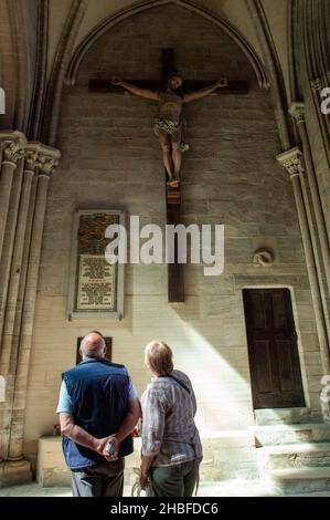 Coppia ammirando la statua di Gesù Cristo sul Crocifisso in una Chiesa in Normandia, Francia Foto Stock