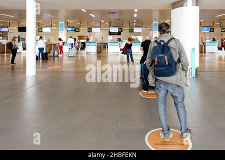 Cartello "Keep your distance" all'aeroporto di Faro, Portogallo, in quanto i viaggiatori si accodano per effettuare il check-in per il loro volo Foto Stock