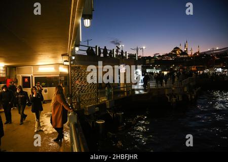 Istanbul, Turchia. 19th Dic 2021. La gente cammina lungo il sottopassaggio del Ponte Galata, con la Moschea Suleymaniye sullo sfondo. Credit: SOPA Images Limited/Alamy Live News Foto Stock