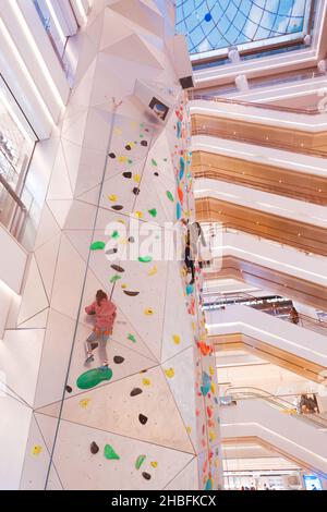 SHANGHAI, CINA - 19 DICEMBRE 2021 - gli appassionati di fitness invernali possono sperimentare la parete di arrampicata al coperto più alta del mondo al New World Mall, una com Foto Stock