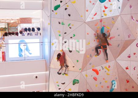 SHANGHAI, CINA - 19 DICEMBRE 2021 - gli appassionati di fitness invernali possono sperimentare la parete di arrampicata al coperto più alta del mondo al New World Mall, una com Foto Stock